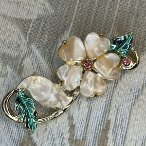 Mementos flower brooch trimmed with rhinestones.